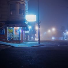 an empty street at night with fog on the ground