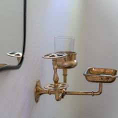 a close up of a wall mounted faucet with a cup on it's side