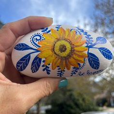 a painted rock with a sunflower on it