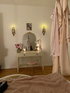 a bedroom with a bed, dressing table and mirror on the wall next to it