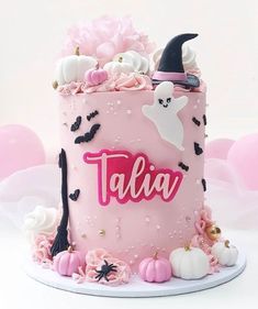 there is a pink cake with white and black decorations on it that says talia