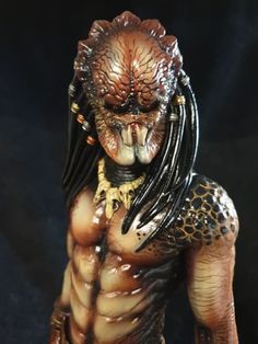 a close up of a statue of a creature with long hair and fangs on it's face