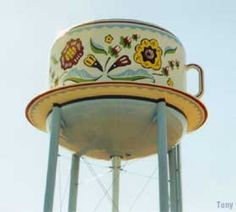 an old fashioned water tower with flowers painted on it's sides and the top