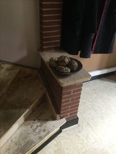 a plate of food sitting on top of a brick wall next to a stair case