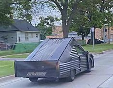 an unusual car is parked on the side of the road