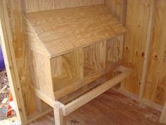 a wooden bench sitting in the corner of a room next to some wood planks