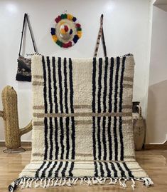 a black and white striped rug sitting on top of a hard wood floor next to a wall