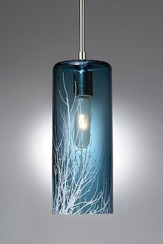 a blue glass hanging light with white branches on the bottom and one light in the middle