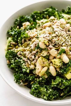 a white bowl filled with broccoli and other food on top of a table