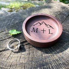 a wooden ring dish with the initials m and l on it sitting on a piece of wood