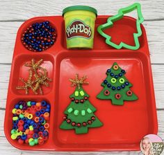 christmas tree play doh tray on a wooden table with polka dot background and text overlay that reads, christmas tree play doh tray