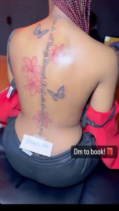 the back of a woman's body with butterflies and words tattooed on her back