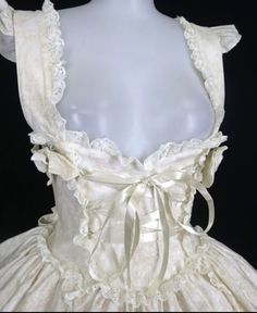 a white dress with lace and bows on it