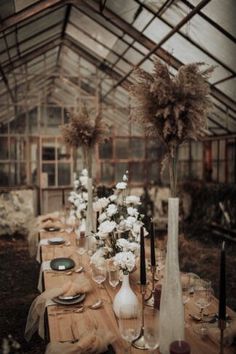 a long table is set with flowers and place settings