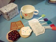 some cookies are sitting on a table next to a cup and cookie cutters with frosting