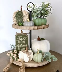 two tiered trays with pumpkins and greenery