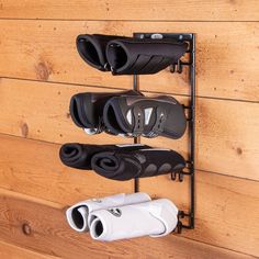 three pairs of shoes hanging on a wooden wall