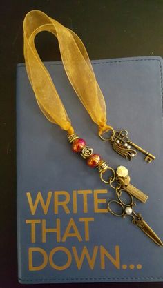 a book with some keys on it and a yellow ribbon around the keychain that says write that down