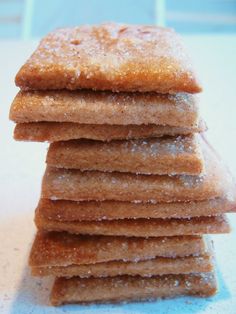 a stack of sugar cookies sitting on top of a white counter covered in powdered sugar