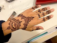 a woman's hand with henna tattoos on it