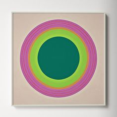 an abstract painting with green, pink and yellow circles in the center on a white wall