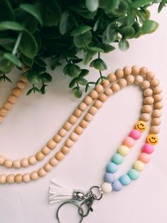 a wooden beaded keychain with two smiley face beads and a tassel