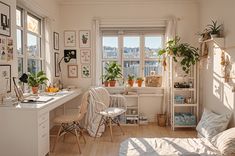 a room filled with lots of plants and furniture next to a window covered in pictures