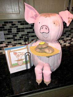 a stuffed pig holding a plate of food