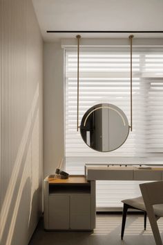 a room with a desk, mirror and chair in it next to a window that has blinds on the windowsill