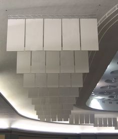 the ceiling is made up of white tiles and glass panels that are hanging from the ceiling