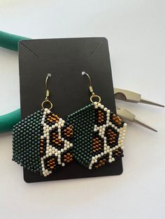 a pair of beaded earrings sitting on top of a table