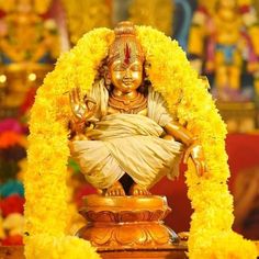 the statue is surrounded by yellow flowers