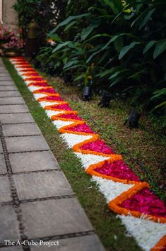 the walkway is lined with white and orange flower petals, which have been laid on top of each other