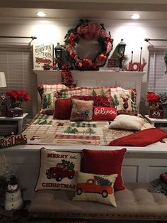 a bedroom decorated for christmas with red and green decorations on the bed, wreaths and pillows