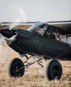 a small airplane sitting on top of a grass covered field