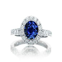 a blue and white diamond ring with diamonds around it's center stone, set in 18k white gold