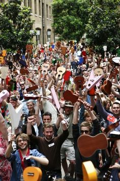 a large group of people holding up musical instruments