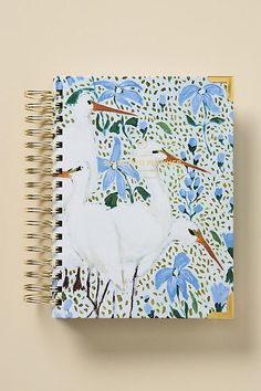 a spiral notebook with an image of a white duck and blue flowers on the cover