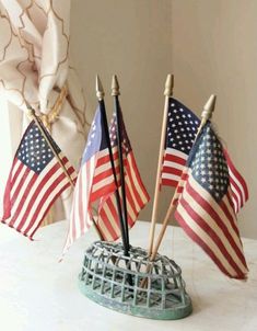 three american flags are placed in a wire basket