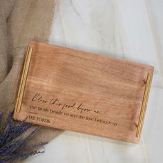 a wooden cutting board with writing on it next to lavenders and burlock