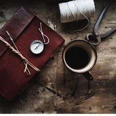 a cup of coffee next to a pair of scissors and a compass on a table