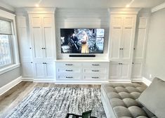 a living room filled with furniture and a flat screen tv on top of a wall