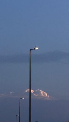 an airplane is flying in the sky above some street lamps and lights at night time