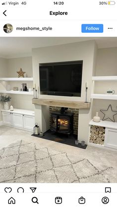 a living room with a fireplace, tv and shelves on either side of the fire place