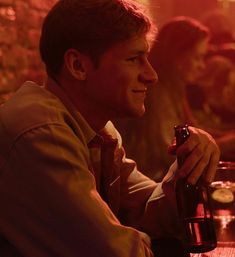 a man sitting at a table with a beer in his hand