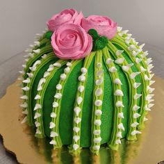 a cake decorated with green icing and pink flowers