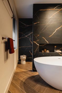 a large white bath tub sitting in a bathroom next to a wall mounted shower head