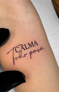 a woman's leg with a tattoo saying calma do paas on it