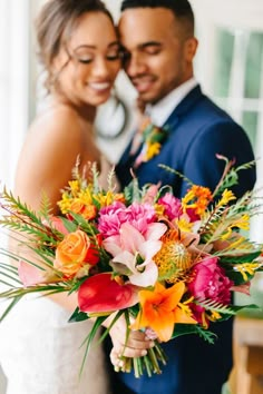 a bride and groom holding a bouquet of flowers