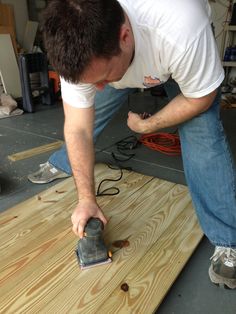 a man sanding wood with an electric sander